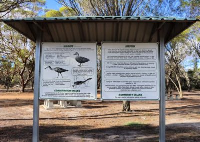 Signs under a shelter describing conservation values of the reserve