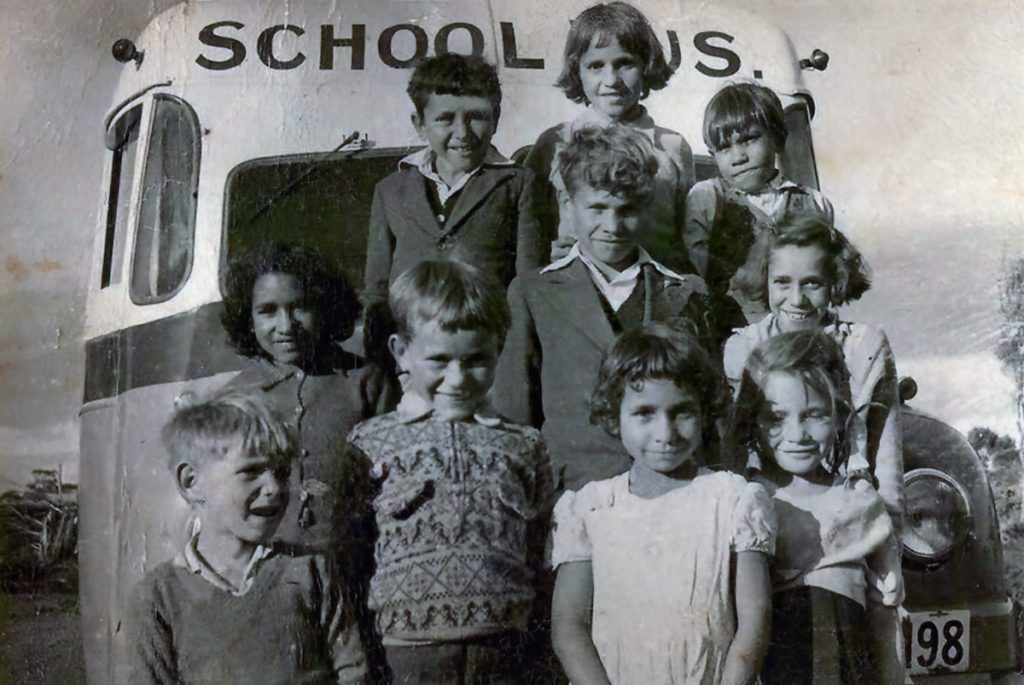 Averil Dean in photo with her Noongar brothers, sisters and cousins heading to school in Tambellup. All standing in front of school bus.